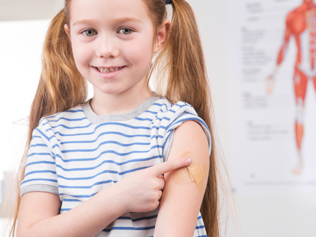 Meisje met pleister na vaccinatie