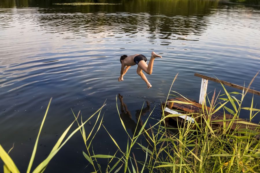 Twee meiden met een muts en bikini doen de handstand op het strand tijdens de nieuwsjaarsduik