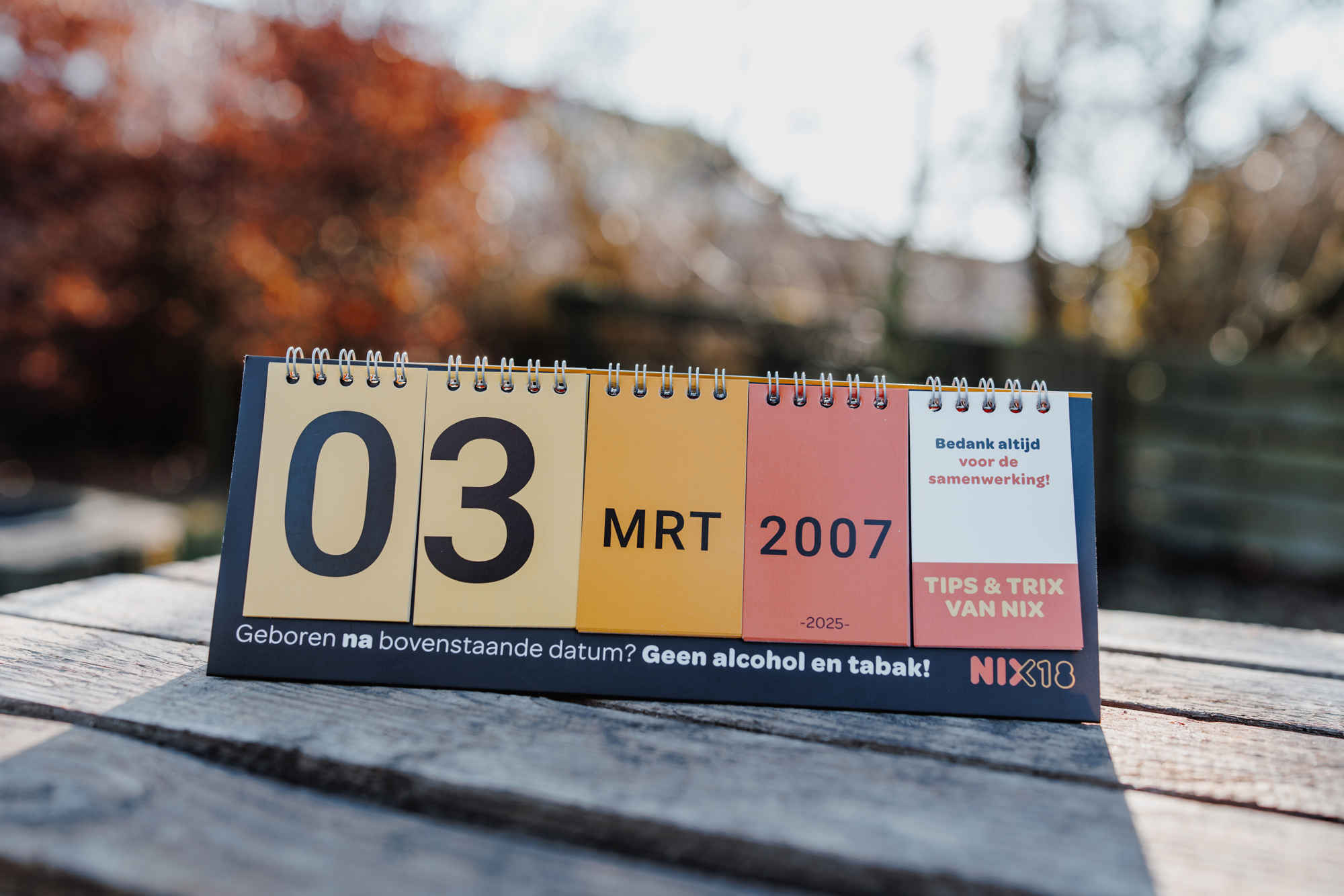 Leeftijdschecker van NIX18 staat buiten op een tafel