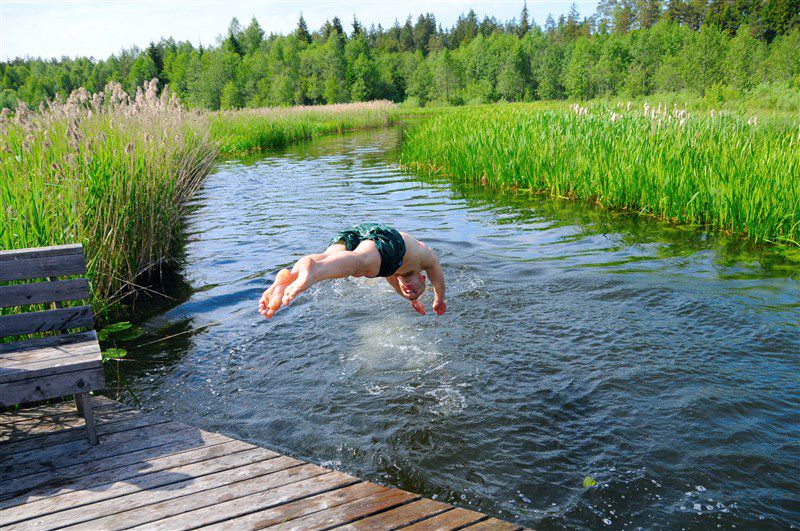 Jongen zwemt in het water met een kerstmuts op